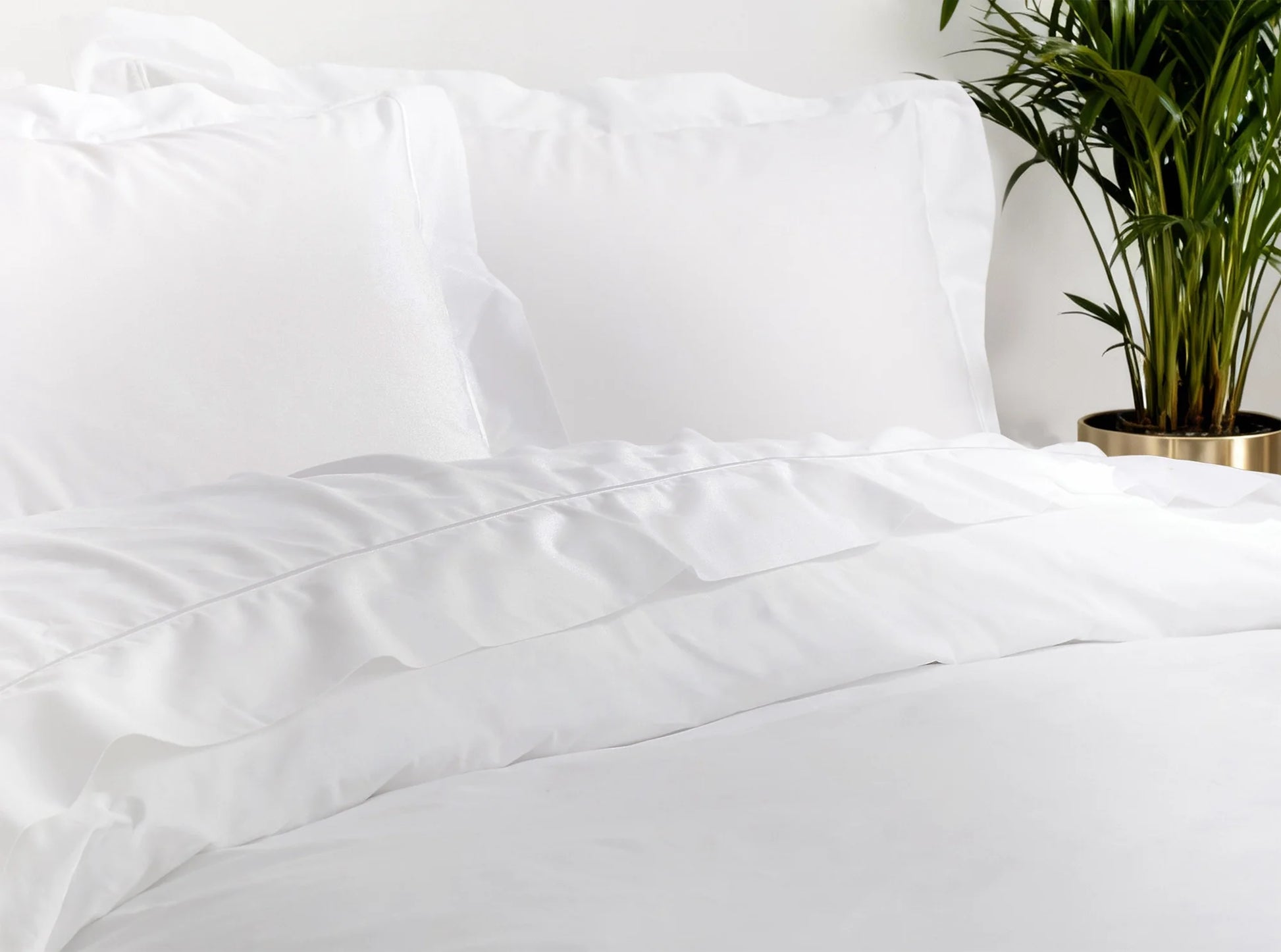 Close-up of white organic cotton percale sheets showing crisp, breathable texture and embroidered detail