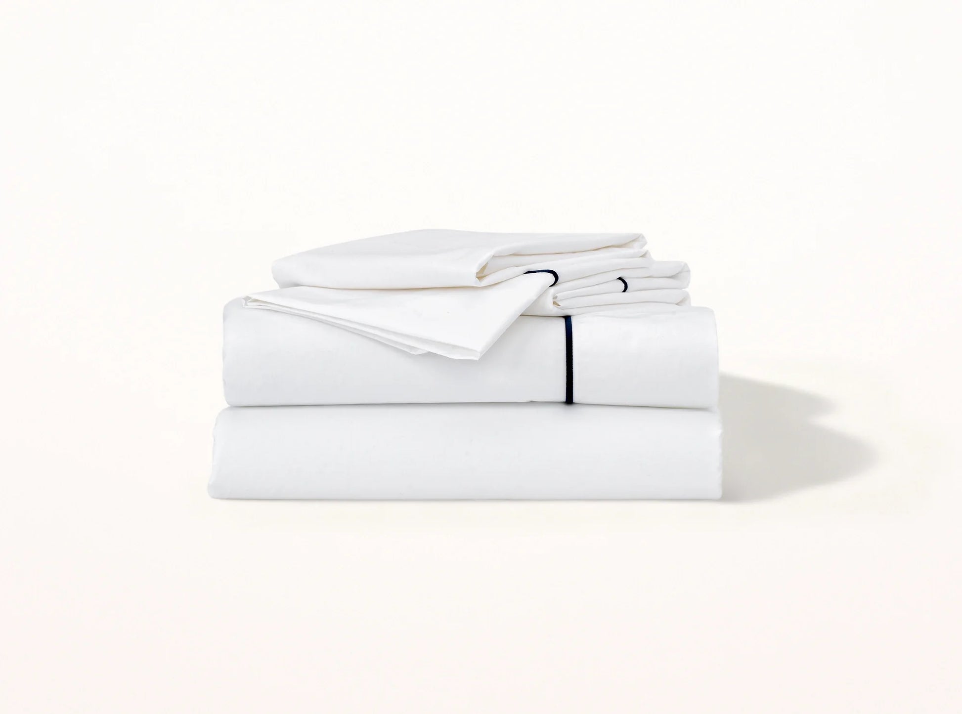 Organic cotton percale sheet set with navy blue embroidered detail on white - elegant contrast