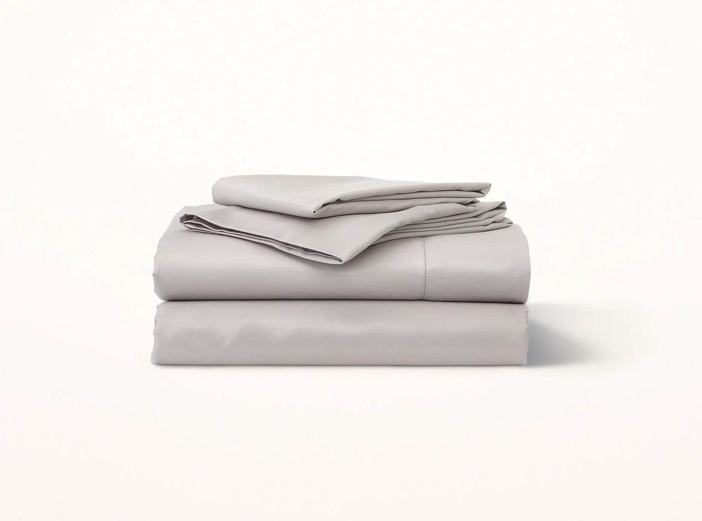 Organic cotton sateen hemstitched sheet set in quiet gray on bed - luxury bedding made in Portugal